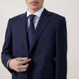 Model wearing Canali dark blue pinstripe suit with white striped shirt and navy tie, buttoning jacket