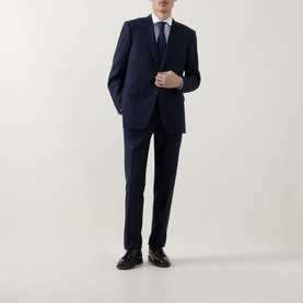 Model wearing Canali dark blue suit with white shirt, blue tie, and black leather shoes