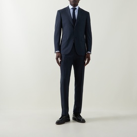 Model wearing Canali navy wool suit with light blue shirt and tie, styled with black leather shoes