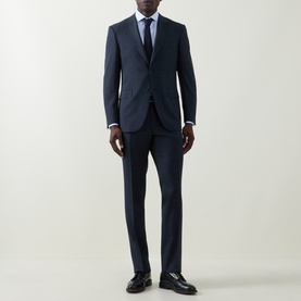 Model wearing Canali navy wool suit, styled with a light blue shirt, navy tie, and black leather loafers.