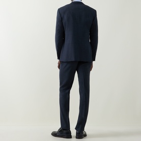 Model wearing Canali navy wool suit, rear view, slim-cut trousers, styled with black leather shoes and light blue shirt.