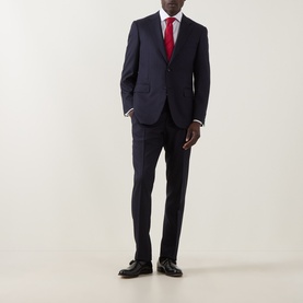 Model wearing Canali D6 Pinstripe Two-Piece Suit in navy wool, styled with a red tie and black dress shoes.