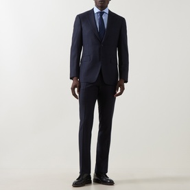 Model wearing Canali dark blue wool suit with slim-fit trousers, styled with a light blue shirt and tie, and dark leather shoes.
