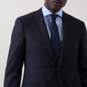 Model wearing Canali dark blue wool suit jacket with notch lapels, styled with light blue shirt and navy tie