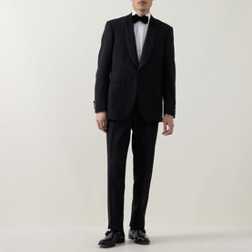Model wearing Canali black tuxedo suit with satin lapels, styled with white dress shirt, black bow tie and black loafers
