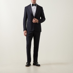 Model wearing Canali D8 Two-Piece Suit in navy, single-breasted jacket with satin peak lapels, styled with black bow tie and dress shoes.