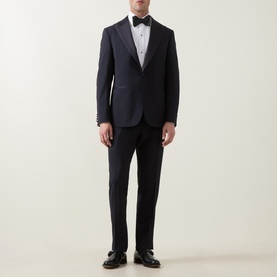 Model wearing Canali D8 Two-Piece Suit in navy wool-mohair blend with satin peak lapels, styled with black bow tie and oxford shoes.