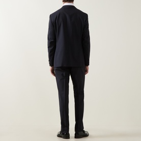 Model wearing Canali D8 Two-Piece Suit in navy, back view showing single-breasted jacket with rear vents and slim-leg trousers.