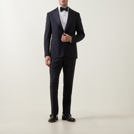 Model wearing Canali D8 Two-Piece Suit in navy, single-breasted jacket with satin peak lapels, styled with black bow tie and dress shoes.