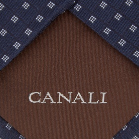 Canali navy silk tie with white geometric dot pattern, brown reverse lining with embroidered Canali logo visible