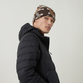 Model with Columbia Jacquard Logo Beanie Hat in Ancient Fossil Camo, styled with a black quilted hooded jacket