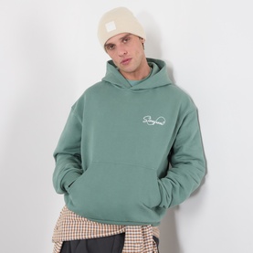 Model with Columbia City Trek&trade; Heavyweight Logo Beanie Hat in Chalk, styled with green graphic hoodie and checked shirt