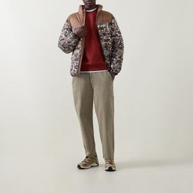 Model wearing Columbia Red Oxide crew neck sweatshirt, styled with floral puffer jacket, khaki trousers and trail trainers.