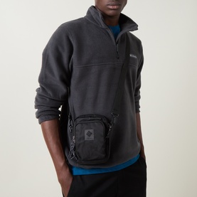 Model carrying Columbia Great Smoky Garden Mini Crossbody Bag in black, worn across body, styled with dark fleece pullover