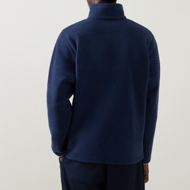 Model wearing Columbia fleece in Collegiate Navy, rear view showing textured back panel and high funnel neck collar.