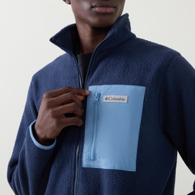 Model wearing Columbia fleece in Collegiate Navy, zip-up with contrasting light blue chest pocket detail, high collar neck