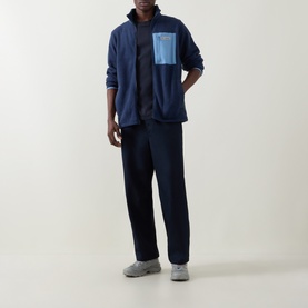 Model wearing Columbia Collegiate Navy fleece zip-up jacket with chest pocket, styled with navy trousers and grey trainers.