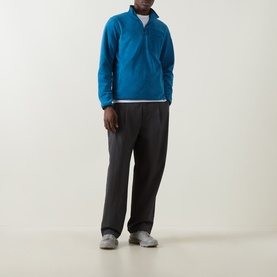 Model wearing Columbia Pacific Arch Logo 200 Zip Fleece Sweatshirt in Phoenix Blue with dark wide-leg trousers and grey trainers.