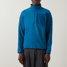 Model wearing Columbia Pacific Arch Logo 200 Zip Fleece Sweatshirt in Phoenix Blue with half-zip, chest pocket, styled with dark trousers.