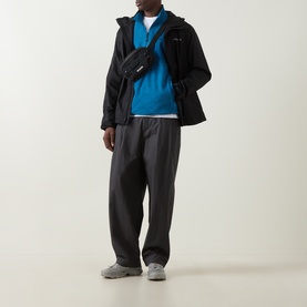 Model wearing Columbia Pacific Arch Logo 200 Zip Fleece in Phoenix Blue, styled with black jacket, dark trousers, and crossbody bag.