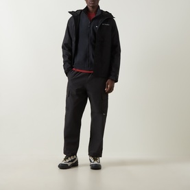 Model wearing Columbia Pacific Arch Logo 200 Zip Fleece Jacket in black, styled with black cargo trousers and trail shoes.