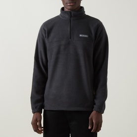 Model wearing Columbia black quarter-zip fleece pullover with funnel neck, chest logo patch and ribbed cuffs