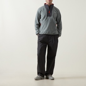 Model wearing Columbia Sequoia Grove II Half Zip Fleece Jacket in Sedona Sage/Shark, styled with black trousers and grey trainers.