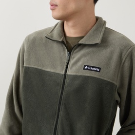 Model wearing Columbia Stone Green fleece jacket with two-tone panelling, full zip fastening and logo badge at chest.