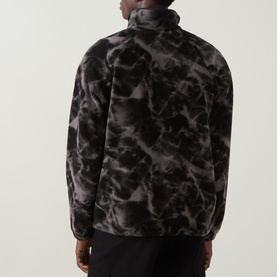 Model wearing Columbia fleece in Black Icepeaks, rear view showing abstract marble print and funnel neck, styled with black trousers.