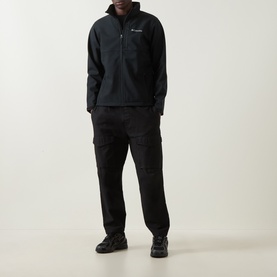 Model wearing Columbia Ascender&trade; Hiking Softshell Jacket in black, styled with black cargo trousers and black trainers.