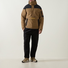 Model wearing Columbia Challenger II Pullover Anorak in Delta/Black colourblock, styled with black cargo trousers and khaki trainers.