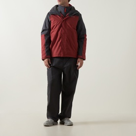 Model wearing Columbia Hikebound II 3-in-1 Waterproof Jacket in Red Oxide and Shark colourblock, styled with black trousers and grey trainers.