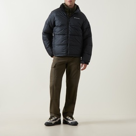 Model wearing Columbia Pike Lake&trade; II Puffer Jacket in black, quilted padded design with hood, styled with olive cargo trousers and trail shoes