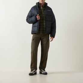 Model wearing Columbia Pike Lake&trade; II Puffer Jacket in black, styled with khaki cargo trousers and hiking trainers.