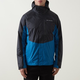 Model wearing Columbia Pouring Adventure&trade; III Waterproof Hiking Jacket in Black and Phoenix Blue colourblock, with fixed hood and zip fastenings