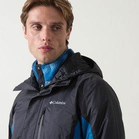 Model wearing Columbia Pouring Adventure&trade; III Waterproof Hiking Jacket in Black/Phoenix Blue colour block, with blue fleece layered beneath