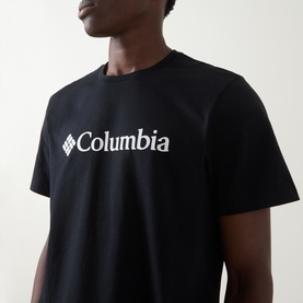 Model wearing Columbia CSC Basic Logo T-Shirt in black, featuring white logo graphic print at chest, round neck, short sleeves