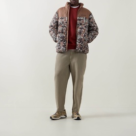 Model wearing Columbia outerwear in Fossil/Camo print with tan collar, styled with khaki trousers and trail trainers.