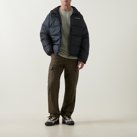 Model wearing Columbia CSC Outdoor Back Graphic T-Shirt in Safari, styled with dark puffer jacket, olive cargo trousers and trail trainers.