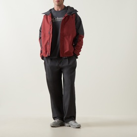 Model wearing Columbia CSC Retro Logo T-Shirt in Shark grey, styled with a red gilet and dark wide-leg trousers.