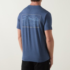 Model wearing Columbia Parons Logo Back Graphic T-Shirt in Collegiate Navy, showing back wave-line graphic print, round neck, short sleeves.