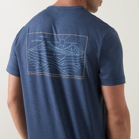 Model wearing Columbia Parsons Logo Back Graphic T-Shirt in Collegiate Navy, showing mountain landscape line-art graphic print on back.