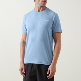 Model wearing Columbia Parons Logo Back Graphic T-Shirt in Rainy Day Heather blue, round neck, short sleeves, paired with dark trousers.