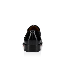 Christian Louboutin black patent leather Oxford shoe, rear view showing heel counter and signature red sole detail.