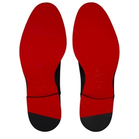 Christian Louboutin black men's shoe soles showing signature red lacquered outsoles with black toe caps, flat lay view.