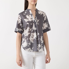 Model wearing Marc O Polo dark grey multi floral cotton blouse with short sleeves, V-neckline, styled with white trousers