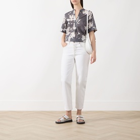 Model wearing Marc O Polo dark grey multi floral cotton blouse with white cropped jeans and silver flatform sandals