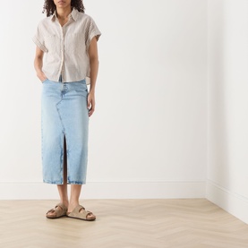 Model wearing Marc O Polo Light Beige cotton blouse with short sleeves and frayed hem, styled with light blue denim midi skirt and tan sandals.