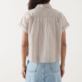 Model wearing Marc O Polo blouse in light beige stripe, short sleeve boxy crop style, back view, styled with light blue denim skirt.
