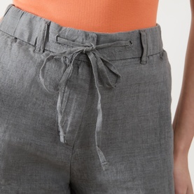 Model wearing Marc O Polo Woven Linen Shorts in Slate Grey Melange, mid-rise with drawstring waistband, styled with an orange top.